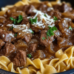 Tender slow cooker beef and noodles in rich onion gravy served over egg noodles