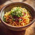 Chili Crisp Noodles served in a bowl with chili oil and spring onions