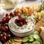 Whipped goat cheese dip platter with bread, crackers, and veggies